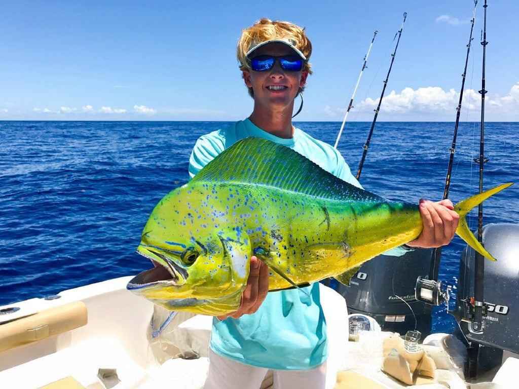 Man sitting on edge of boat looking out into the water wearing BTW performance hoodie.