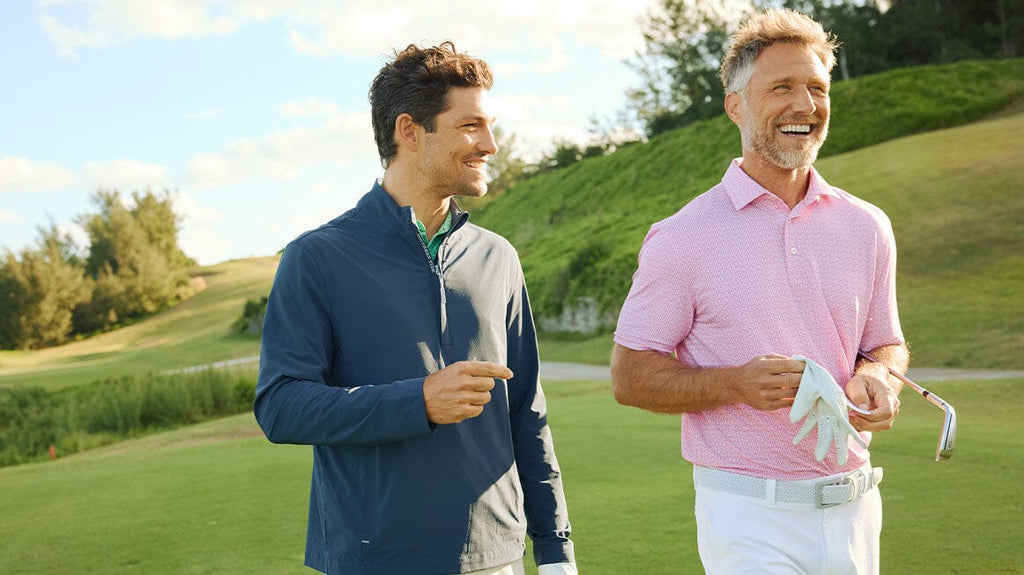 Man on gold course picking up golf ball.