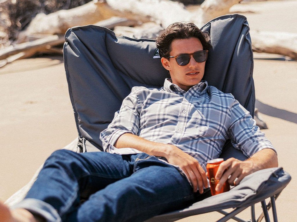 Man lounging on outdoor camping chair.