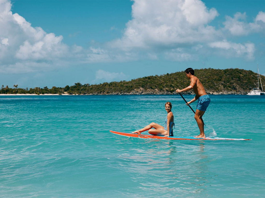 Man and woman on paddle board in the ocean.