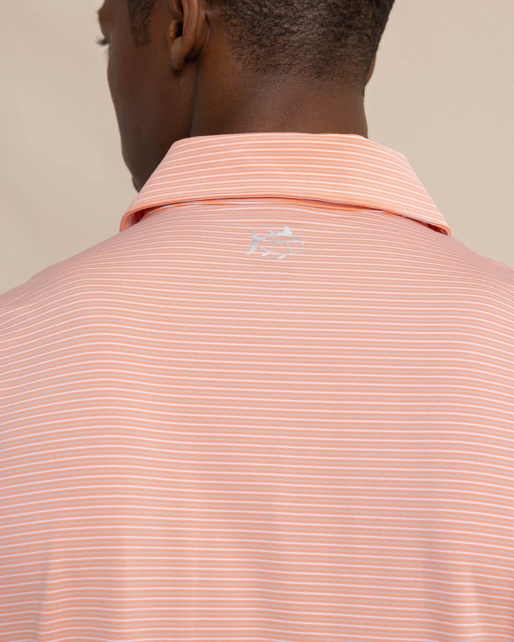 The detail view of the Southern Tide brrr-eeze Baytop Stripe Performance Polo by Southern Tide - Desert Flower Coral