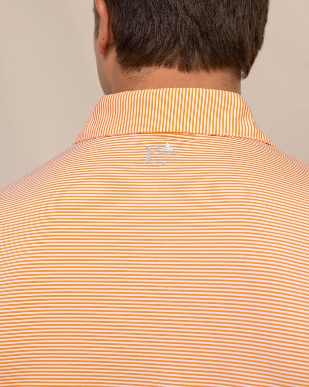 The detail view of the Southern Tide brrr-eeze-meadowbrook-stripe-polo by Southern Tide - Tangerine Orange