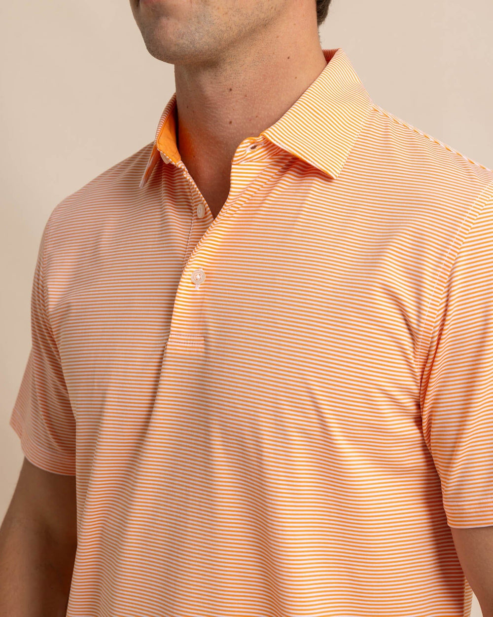 The detail view of the Southern Tide brrr-eeze-meadowbrook-stripe-polo by Southern Tide - Tangerine Orange