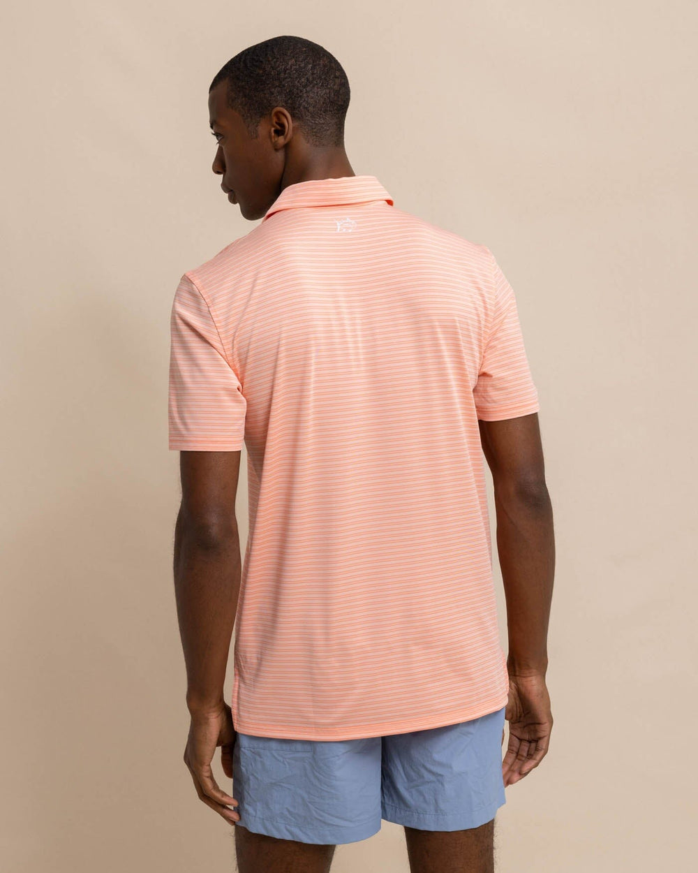 The back view of the Southern Tide brrr eeze Beattie Stripe Performance Polo by Southern Tide - Apricot Blush Coral