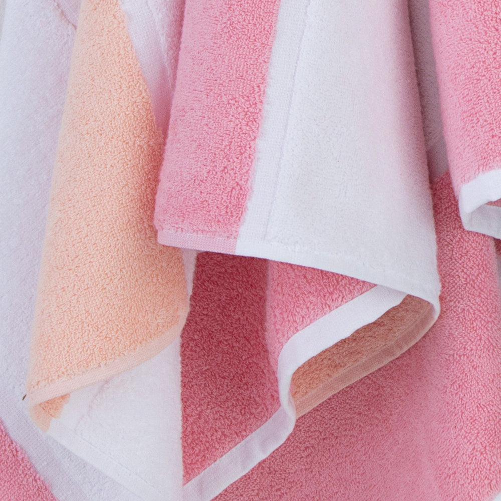 The detail view of the Performance Striped Bath Towel in Coral by Southern Tide - Coral