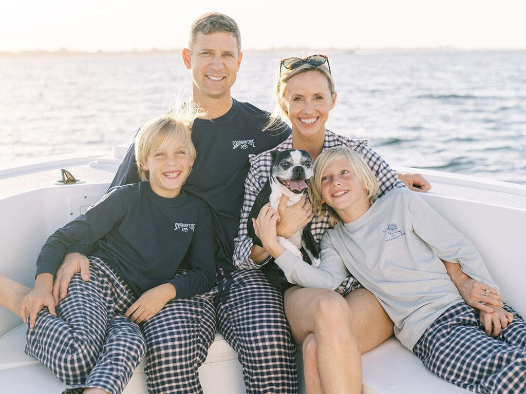 Family on a boat wearing matching Christmas pajamas.
