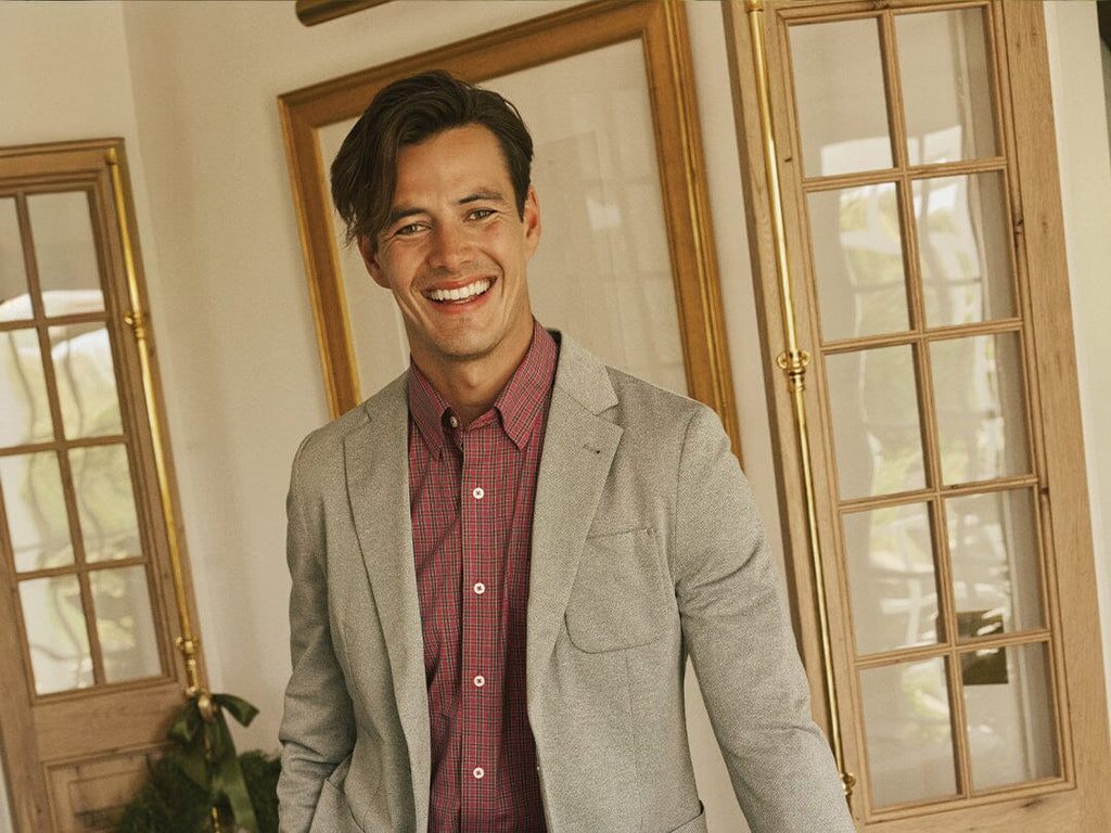 Man in light gray blazer and plaid button down.