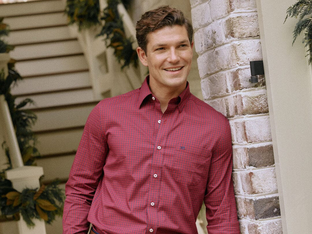 Man wearing sports shirt sitting on porch steps holding a gift.