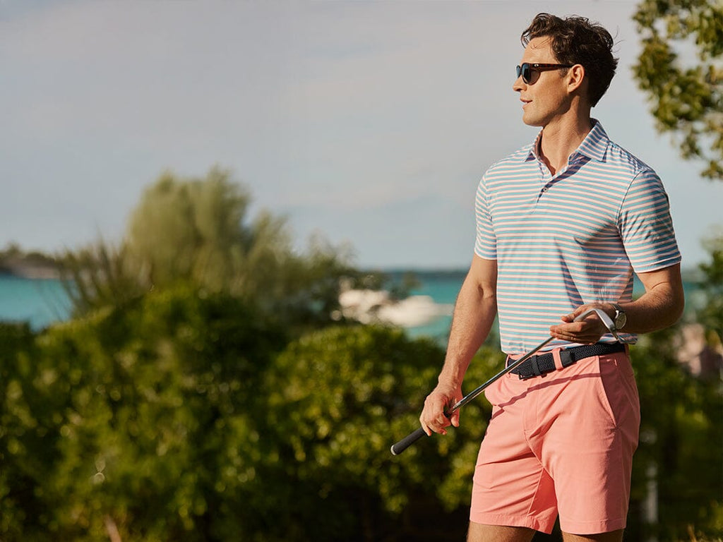Two men and one women standing around a golf cart on a gold course.