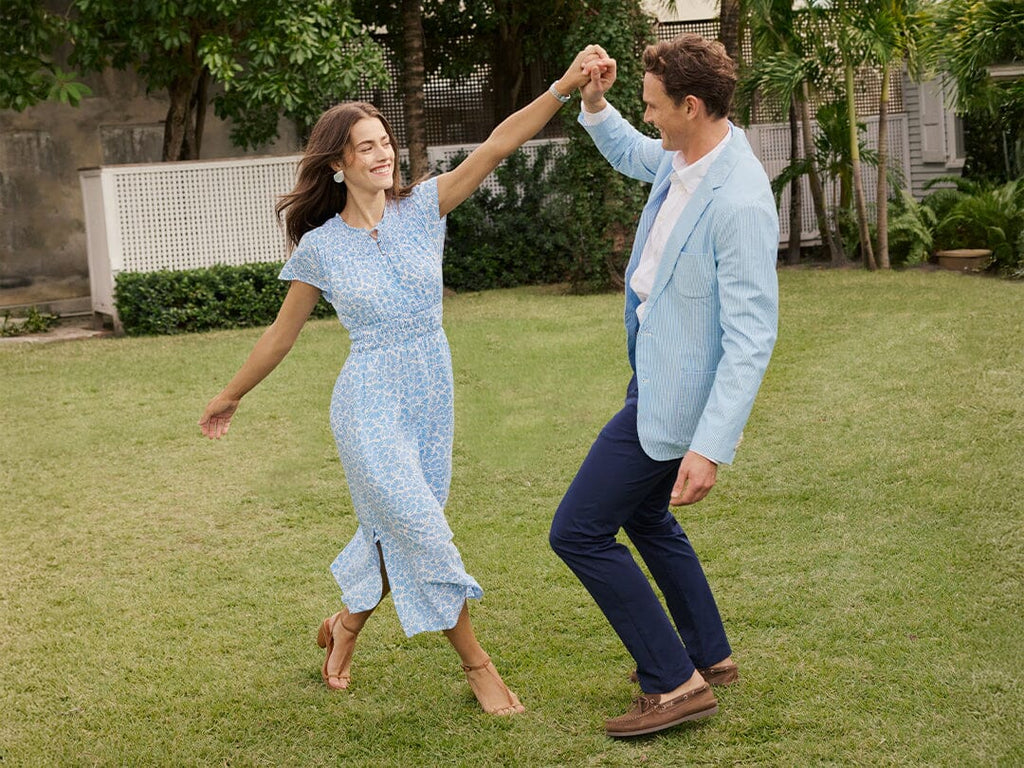 A girl walking towards the camera wearing wearing a tiered dress.