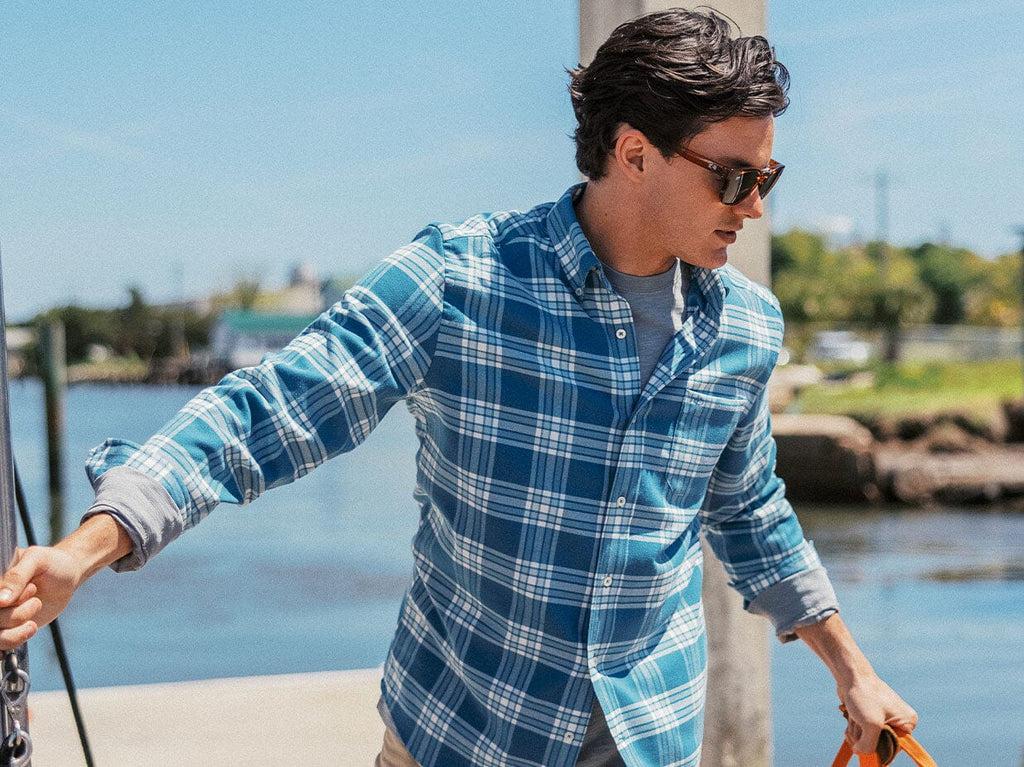 Man wearing Beach Flannel outside holding a bag.