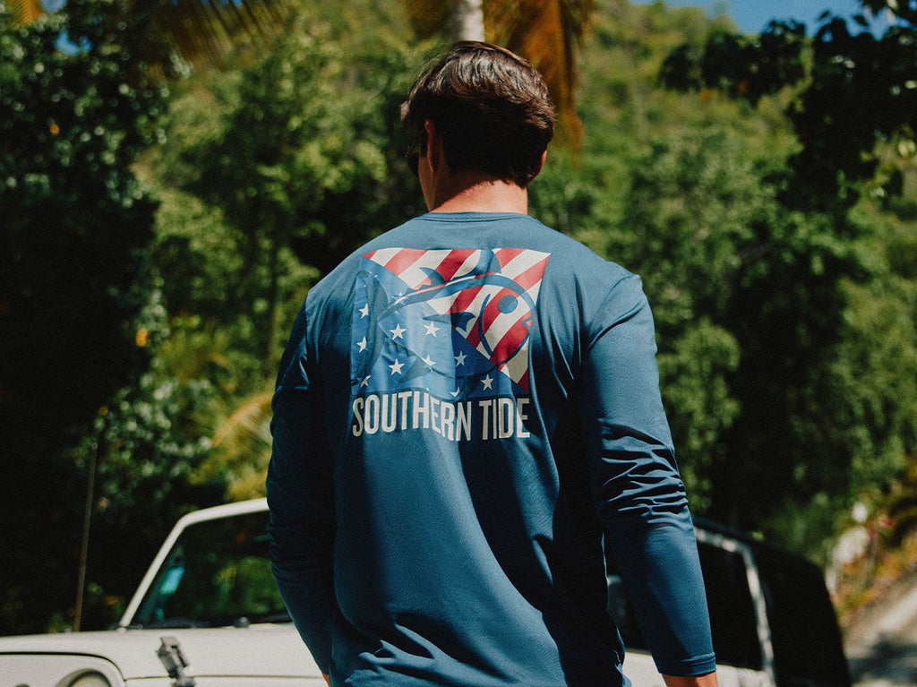 Man wearing Southern Tide T-Shirt with patriotic design walking backwards.