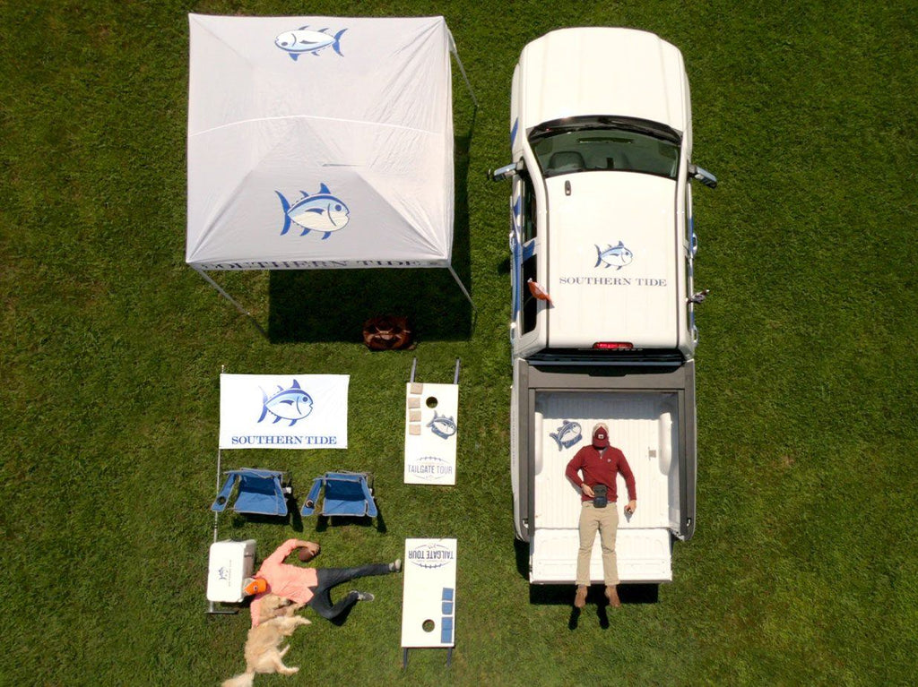 Ariel view of tailgate set up. Includes tent, truck, and cornhole.