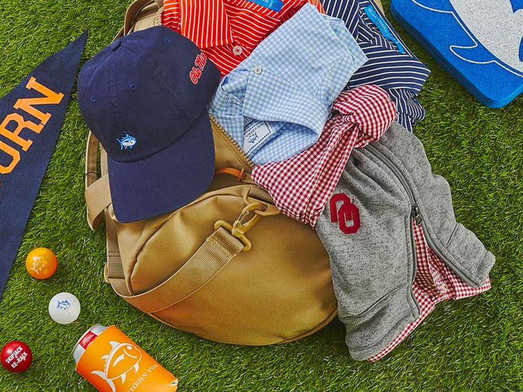 Southern Tide clothing and accessories coming out of a travel bag.