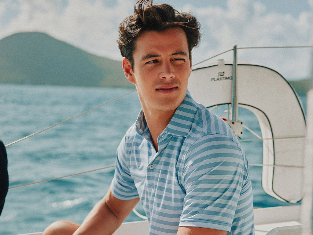 Man wearing striped polo on a boat.