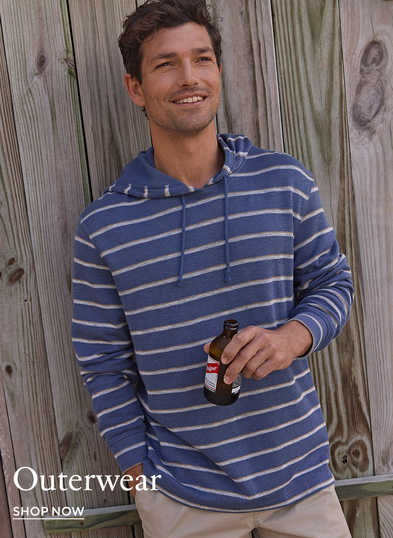 A man wears the Southern Tide Bay View Stripe Hoodie, displaying its striped pattern and relaxed fit. Suitable for casual wear and cool weather.