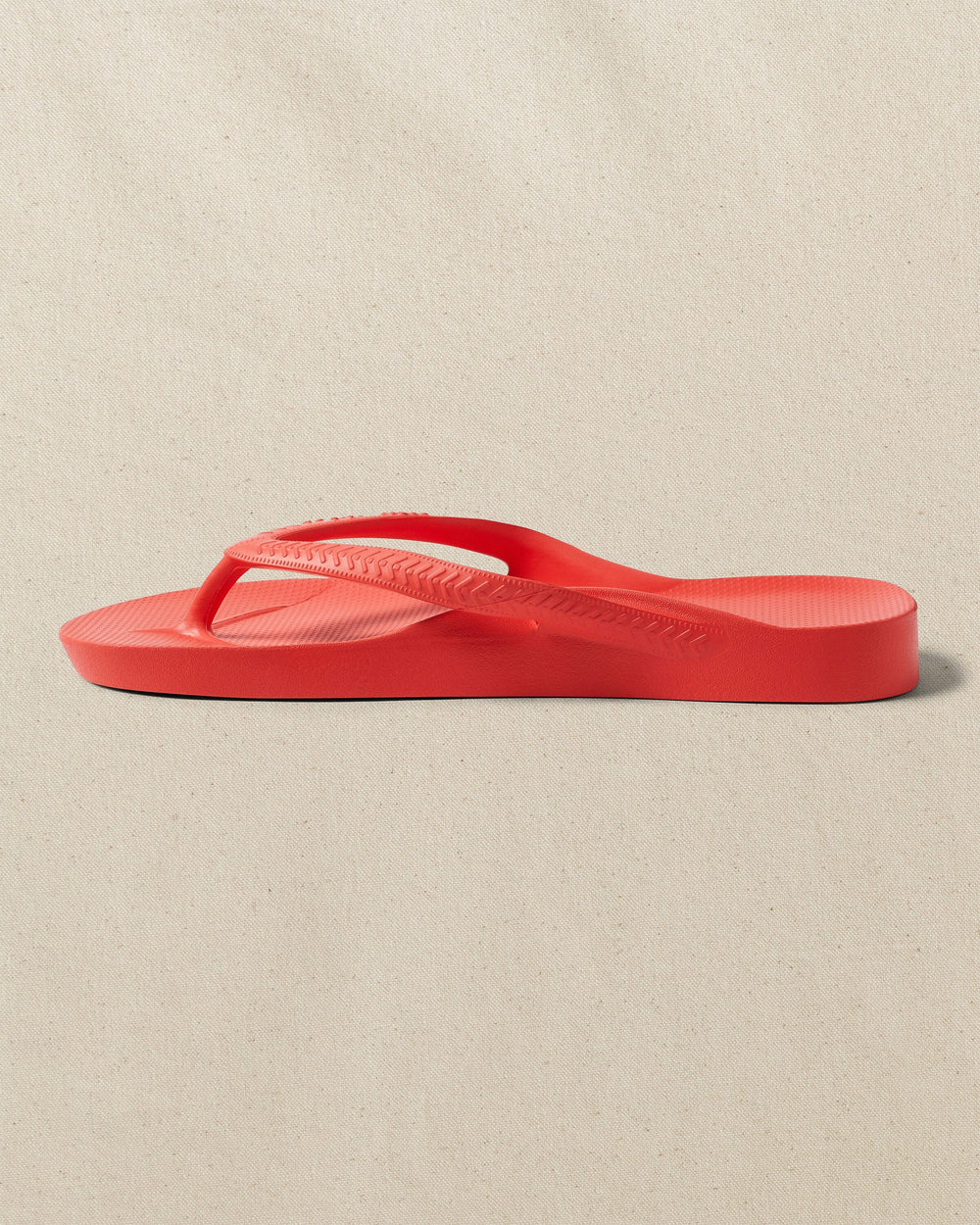 The left side view of the Southern Tide Archie's Coral Arch Support Flip Flop by Southern Tide - Coral