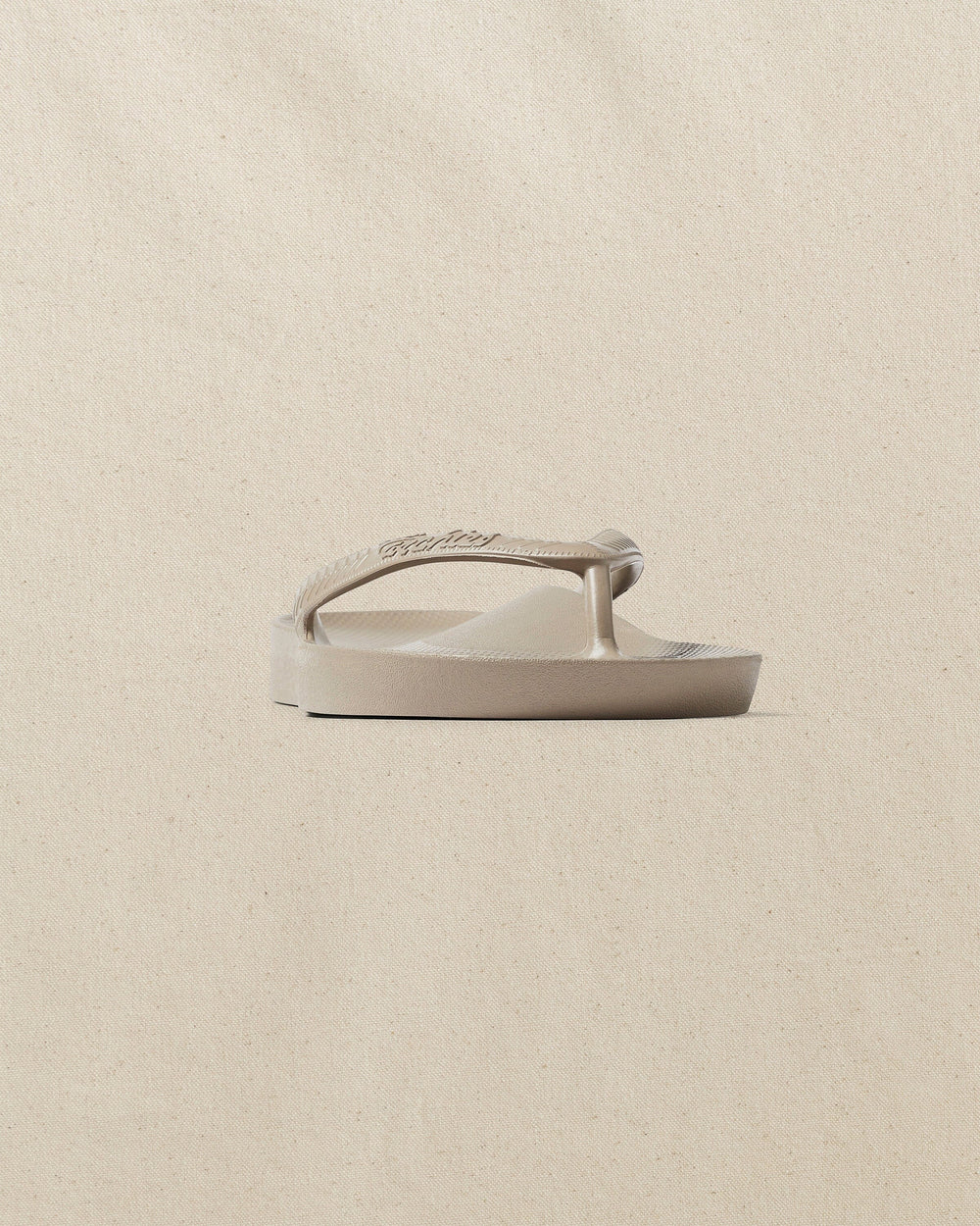 The front side view of the Southern Tide Archie's Taupe Arch Support Flip Flop by Southern Tide - Taupe