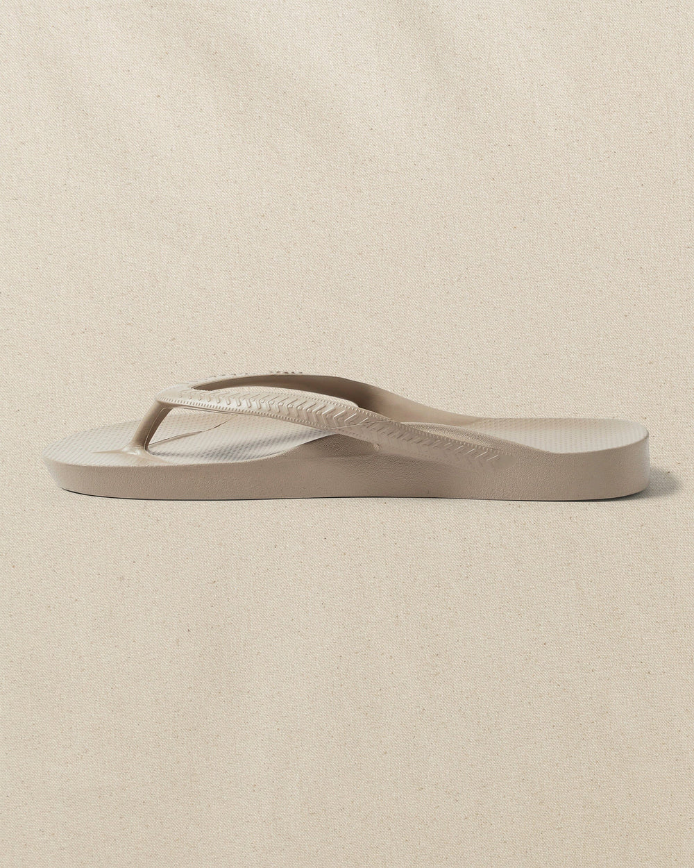 The left side view of the Southern Tide Archie's Taupe Arch Support Flip Flop by Southern Tide - Taupe