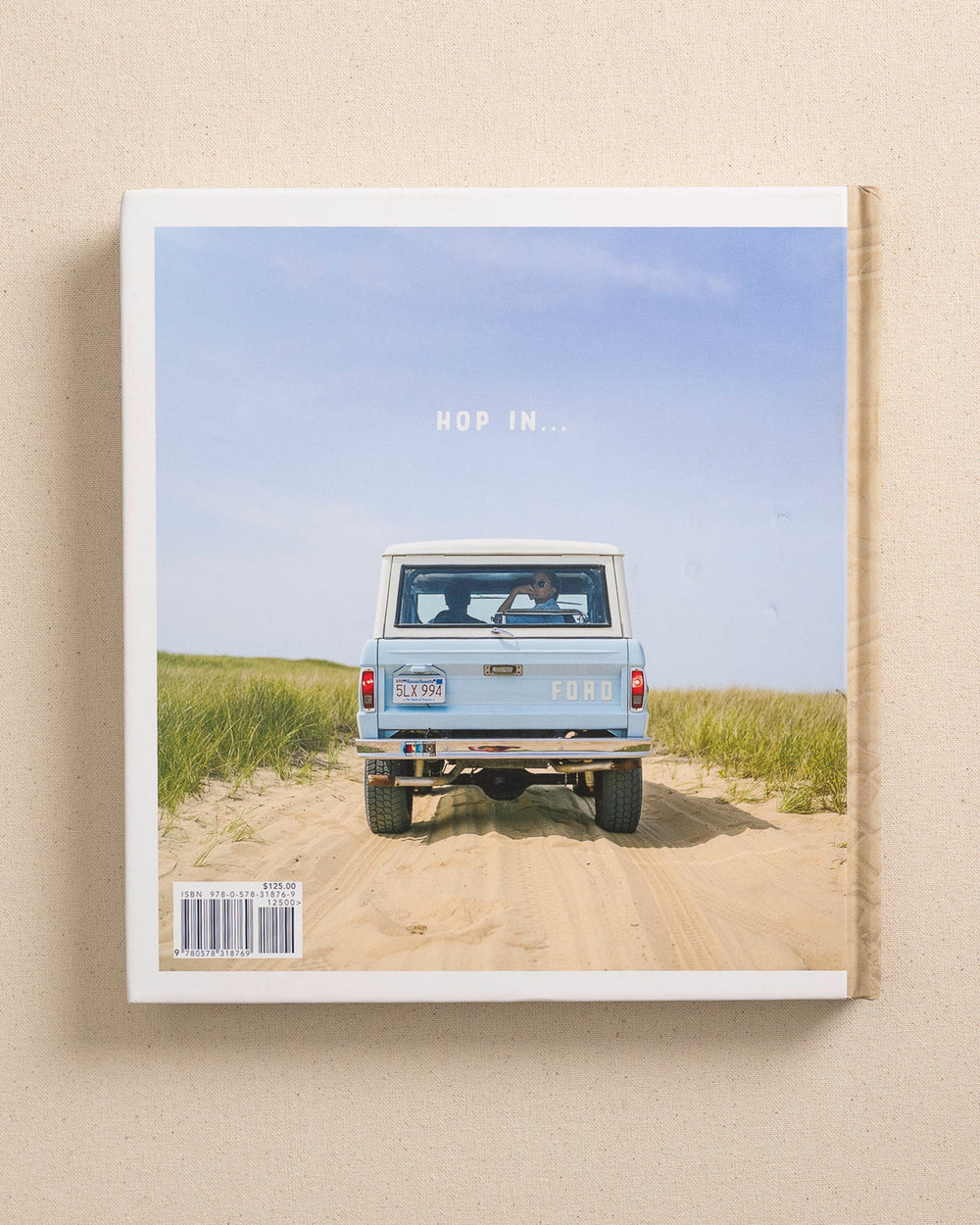 The back view of the Johnny Vacay Beach Rides Coffee Table Book at Southern Tide - White