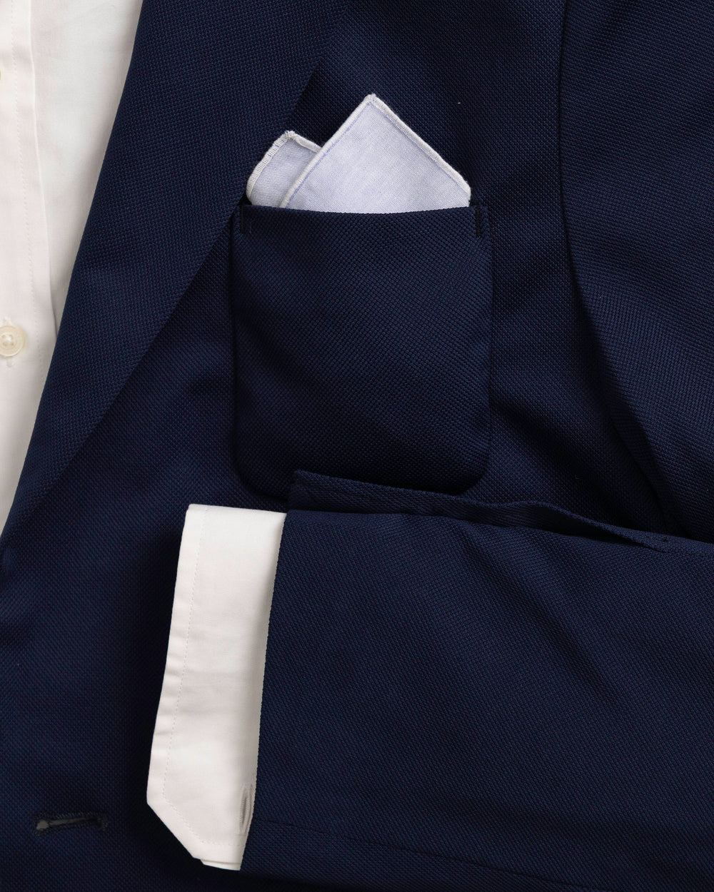 The detail coat view of the High Cotton Blue Chambray Pocket Square at Southern Tide - Blue