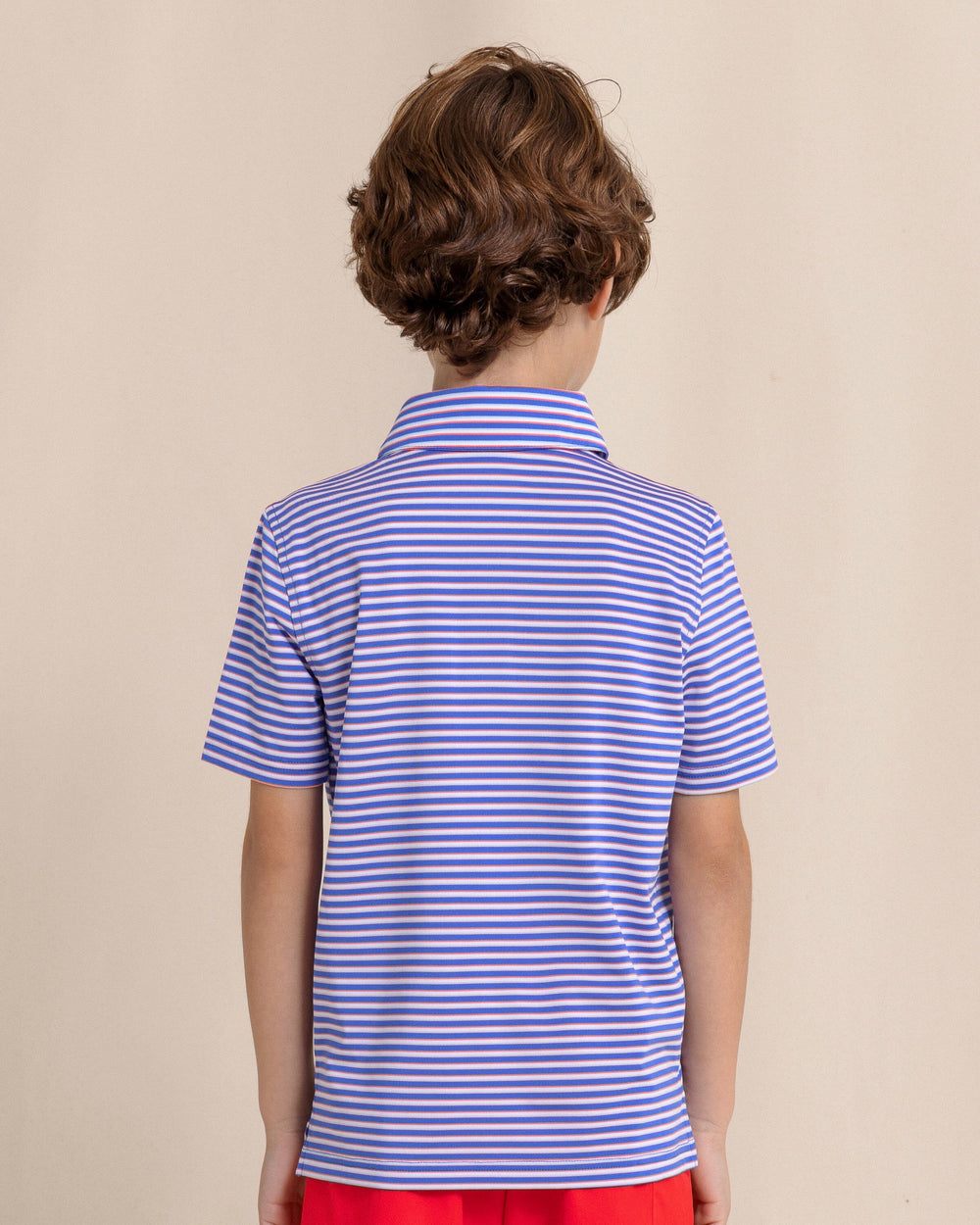 The back view of the Southern Tide Kids Driver Caravel Stripe Performance Polo by Southern Tide - Dazzling Blue