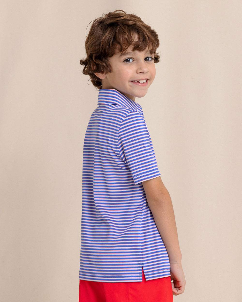 The side view of the Southern Tide Kids Driver Caravel Stripe Performance Polo by Southern Tide - Dazzling Blue