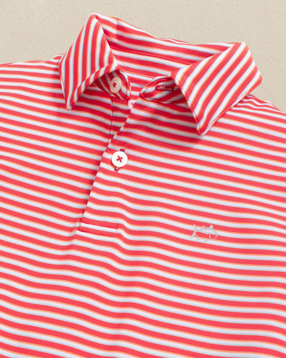 The detail view of the Southern Tide Kids Driver Caravel Stripe Performance Polo by Southern Tide - Poppy Red