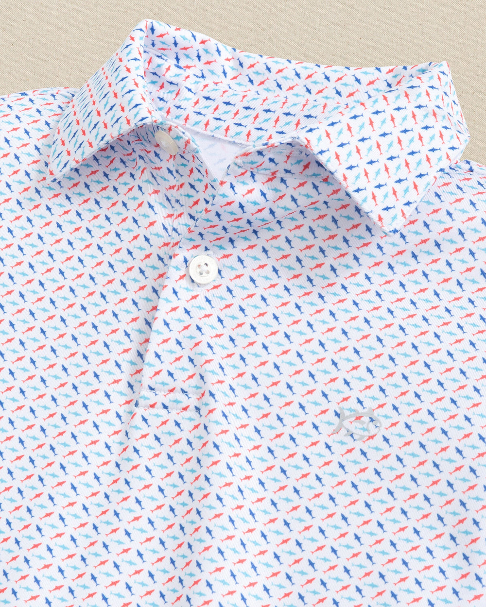 The detail view of the Southern Tide Boys Driver Fin-tastic Catch Printed Performance Polo by Southern Tide - Classic White