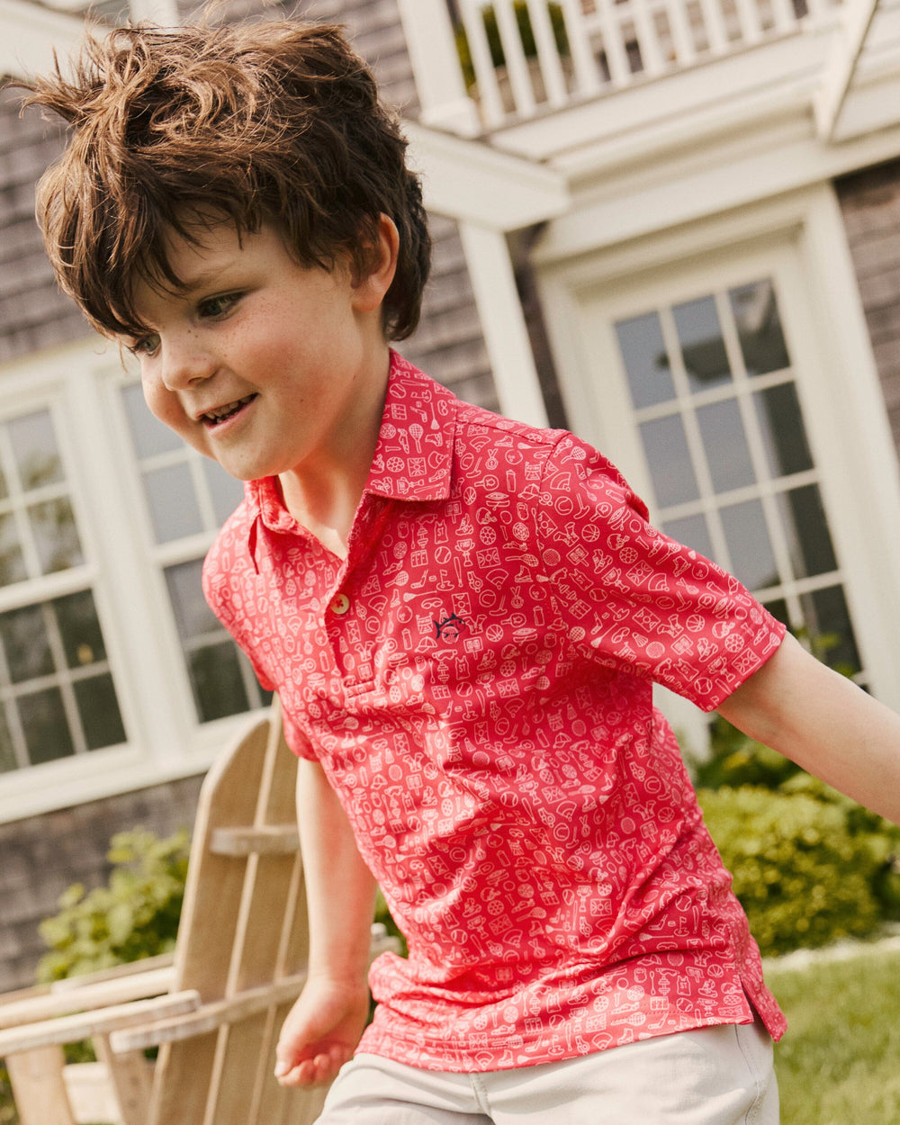 The lifestyle view of the Southern Tide Boys Driver Finally Friday Printed Performance Polo by Southern TIde - Snapper