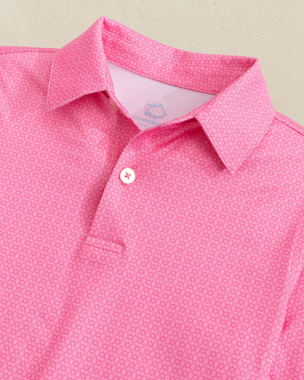 The detail view of the Southern Tide Boys Driver Seaside Geo Printed Performance Polo by Southern Tide - Sea Pink
