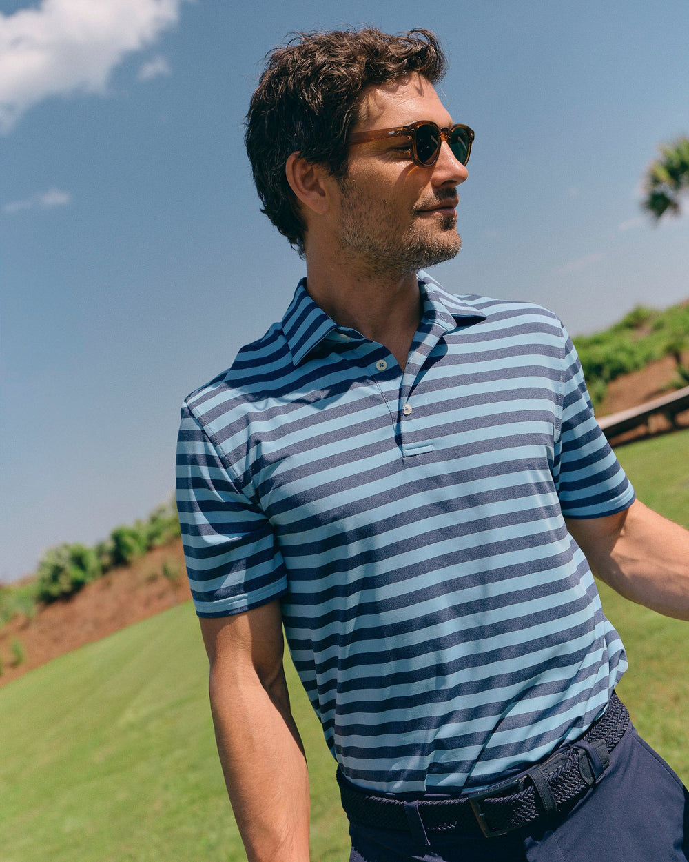 The lifestyle view of the Southern Tide Brewers Landing Stripe Coastal Breeze® Performance Polo by Southern Tide - Heather Ocean Channel