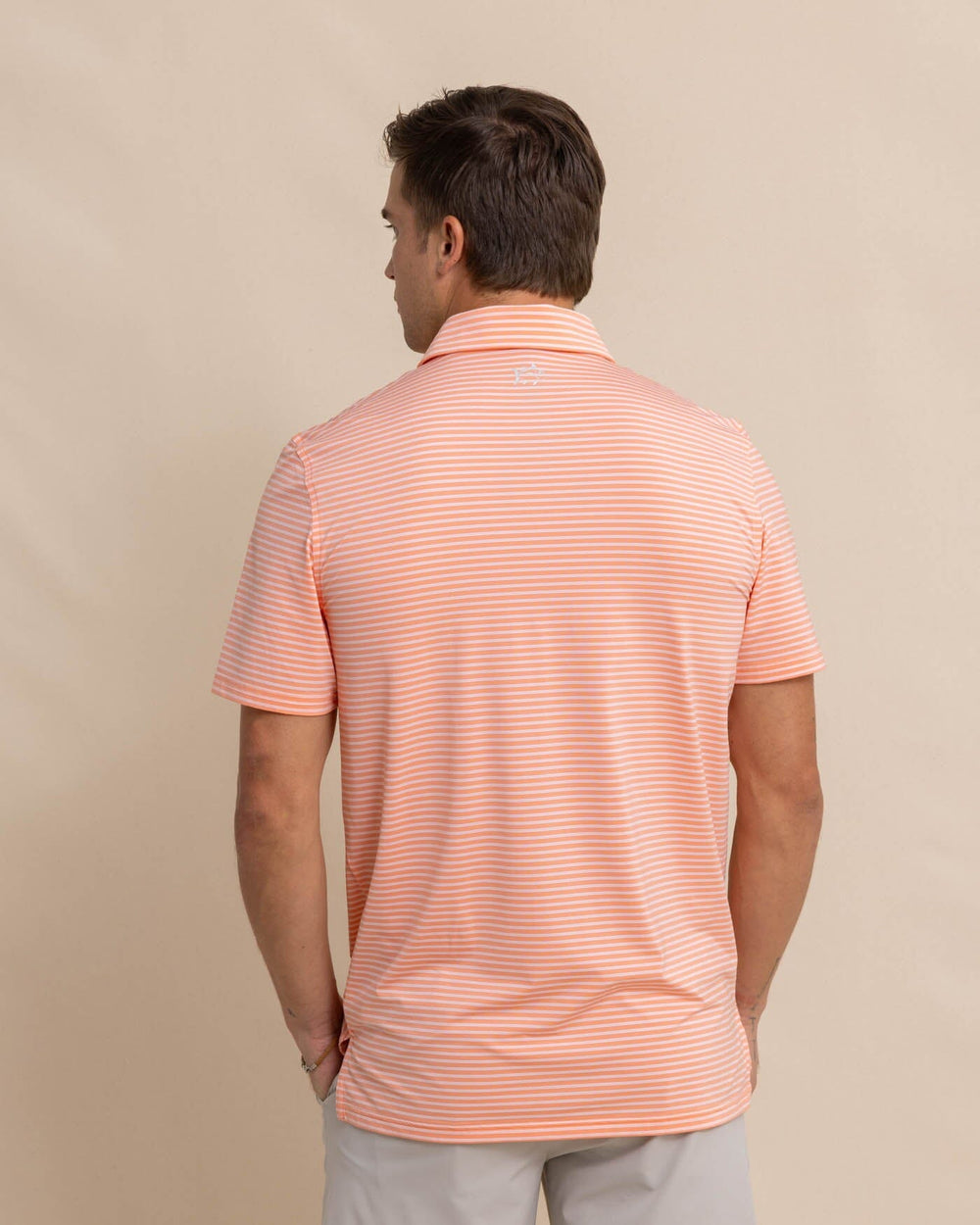 The back view of the Southern Tide brrr eeze Beattie Stripe Performance Polo by Southern Tide - Desert Flower Coral