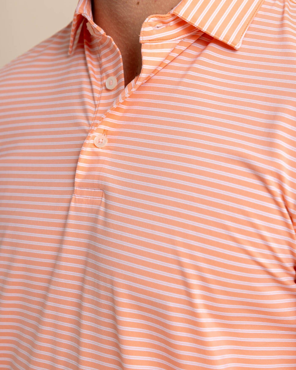 The detail view of the Southern Tide brrr eeze Beattie Stripe Performance Polo by Southern Tide - Desert Flower Coral
