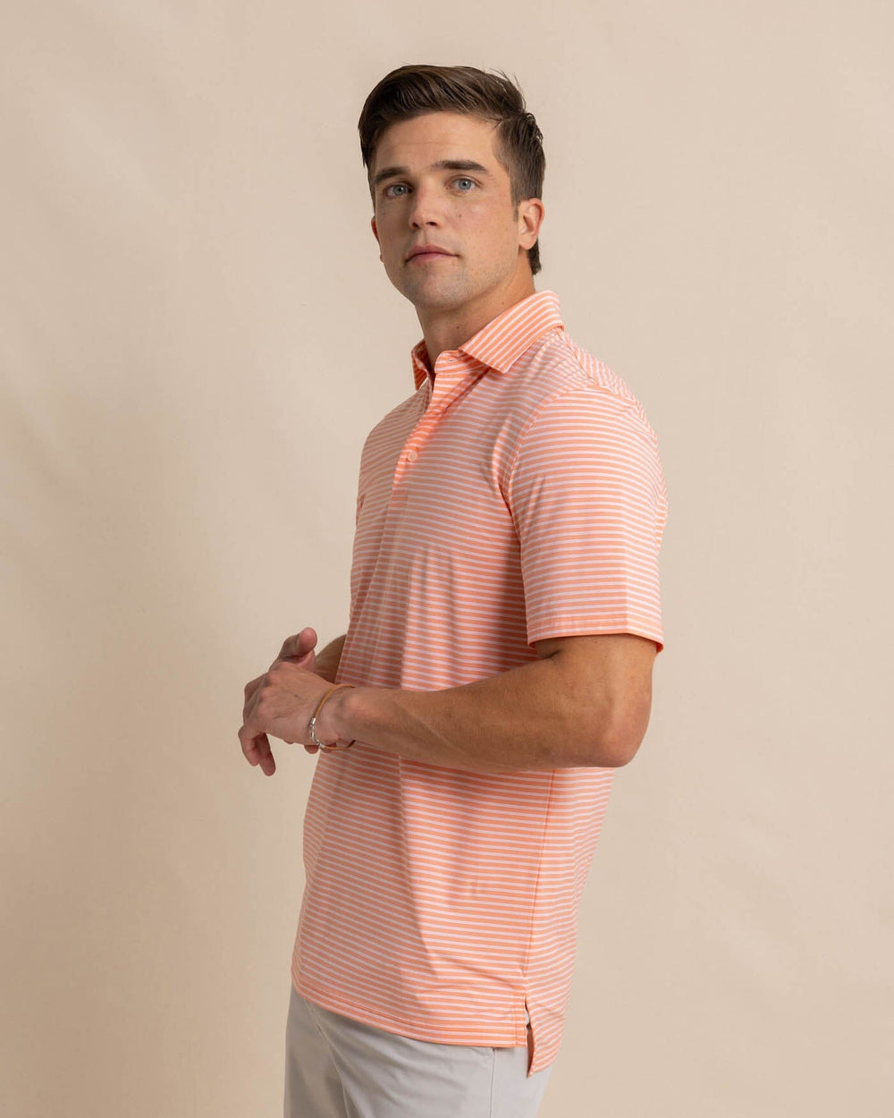 The front view of the Southern Tide brrr eeze Beattie Stripe Performance Polo by Southern Tide - Desert Flower Coral