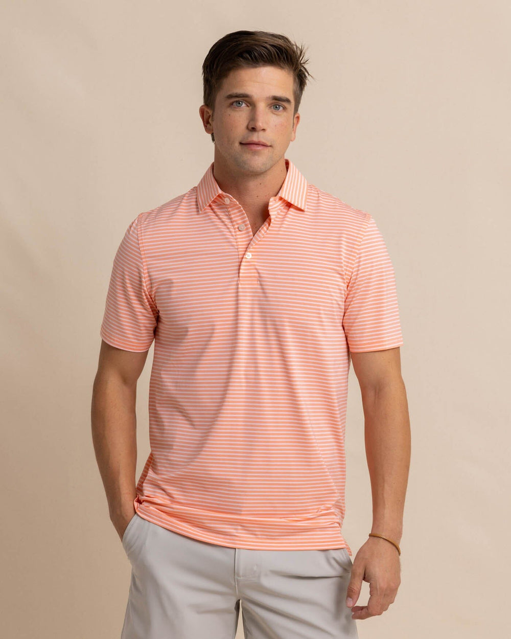The front view of the Southern Tide brrr eeze Beattie Stripe Performance Polo by Southern Tide - Desert Flower Coral