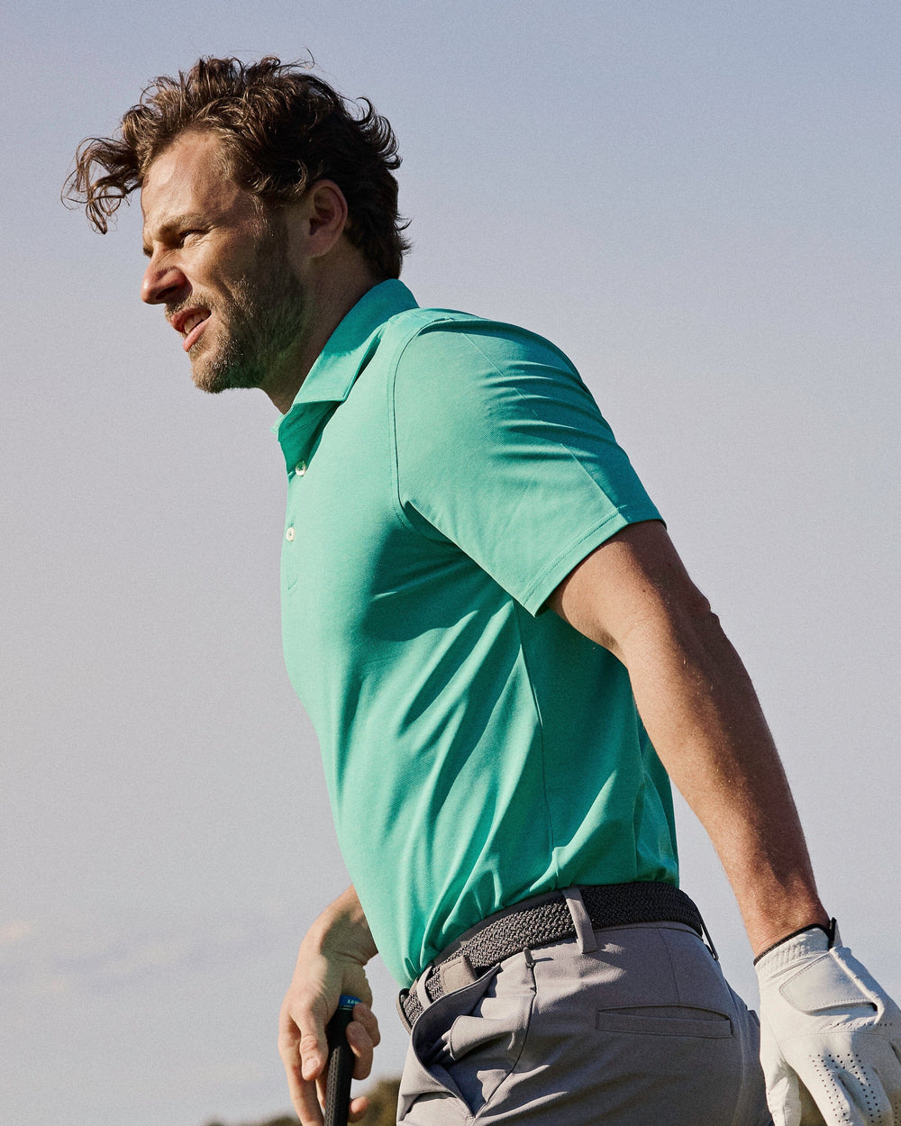 The lifestyle view of the Southern Tide brrr°®-eeze Heather Performance Polo Shirt by Southern Tide - Heather Turtle Green