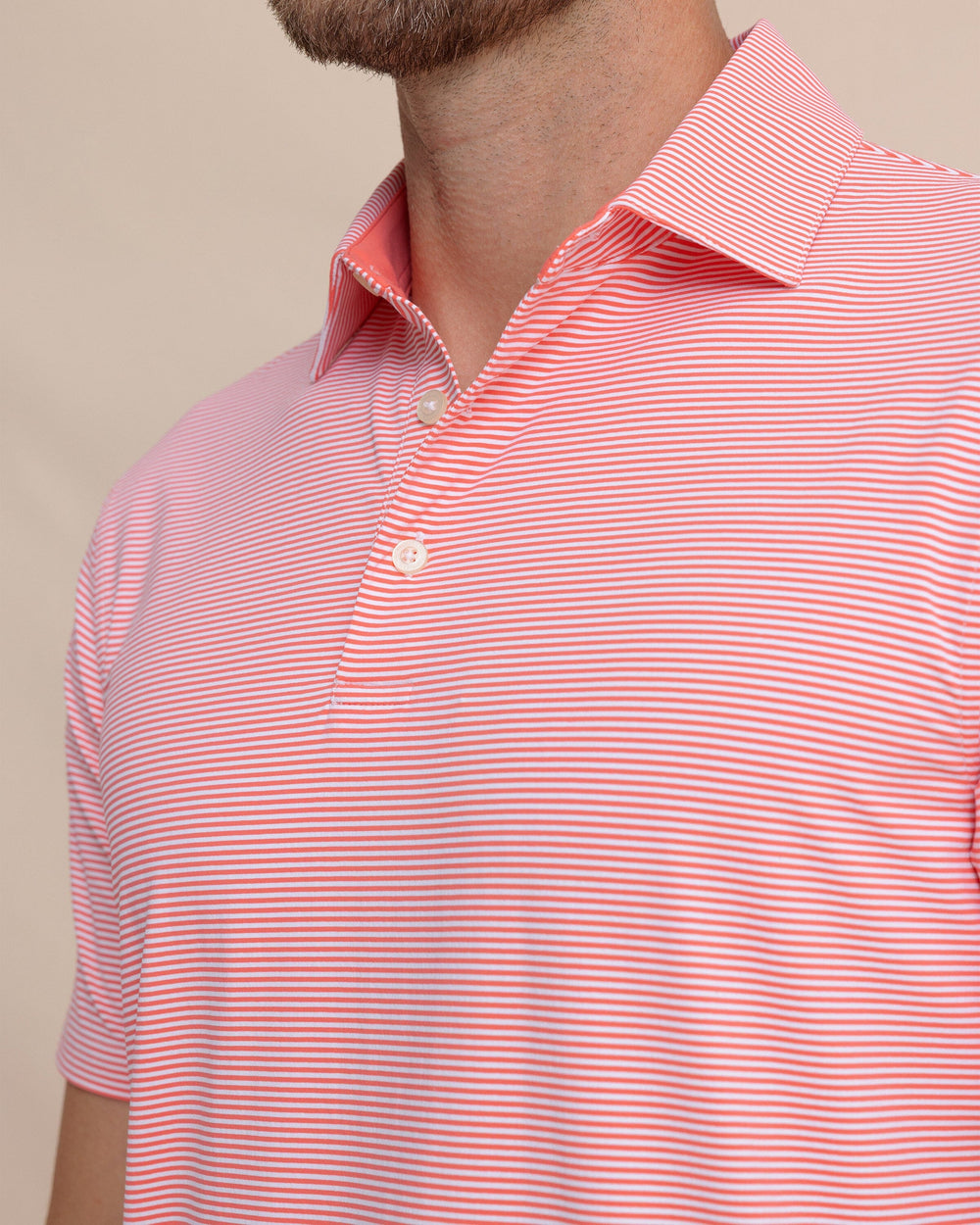 The detail view of the Southern Tide brrr°®-eeze Meadowbrook Stripe Polo by Southern Tide - Sunkist Coral