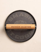 The top view of the Burger Master Cast Iron Grill Press at Southern Tide - Natural