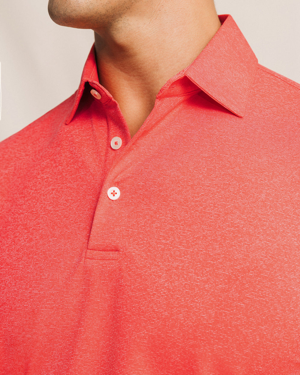 The detail view of the Southern Tide Coastal Breeze® Heather Performance Polo by Southern Tide - Heather Channel Marker Red
