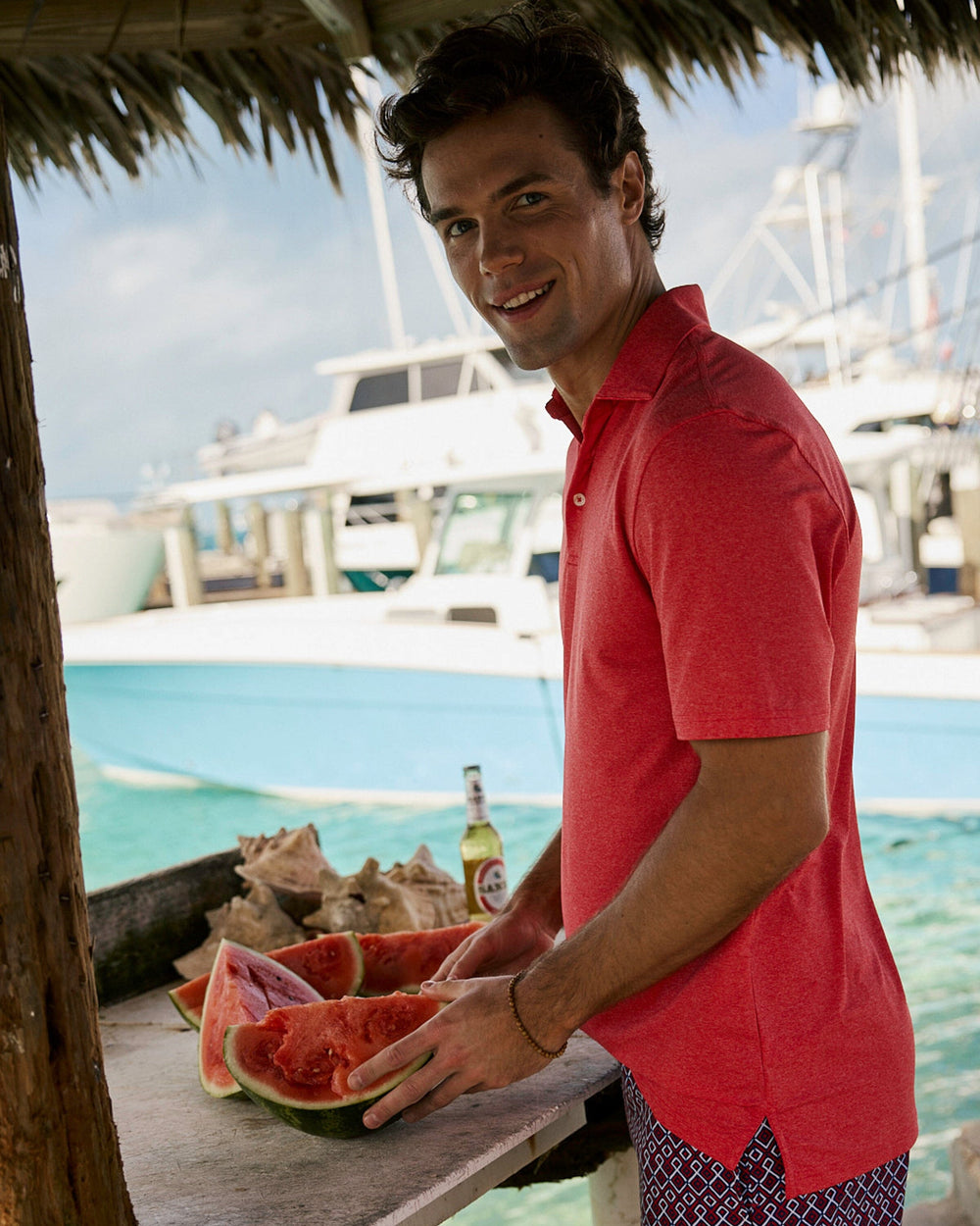 The lifestyle view of the Southern Tide Coastal Breeze® Heather Performance Polo by Southern Tide - Heather Channel Marker Red
