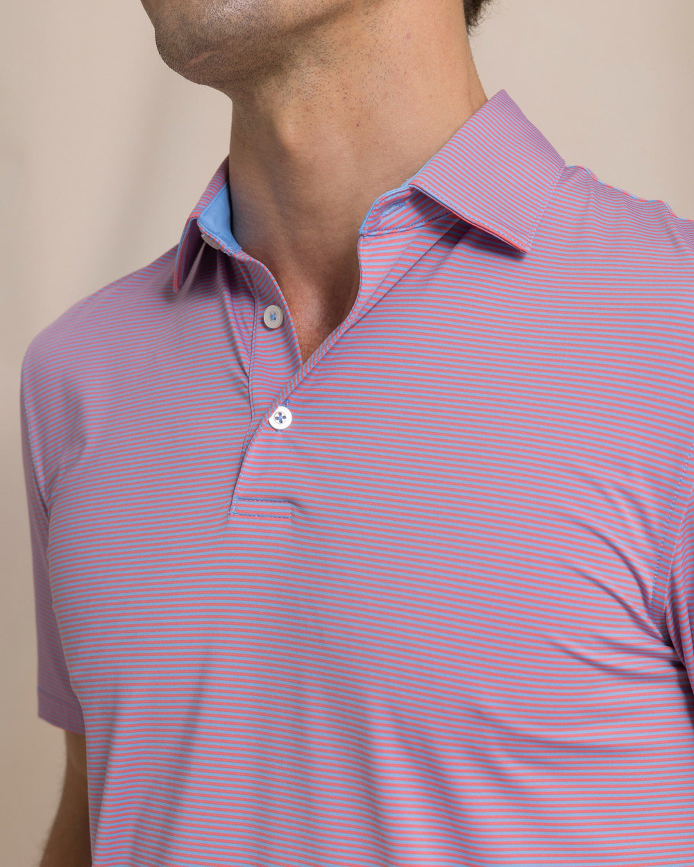 The detail view of the Southern Tide Coastal Breeze® Meadowbrook Stripe Performance Polo by Southern Tide - Coral Beach