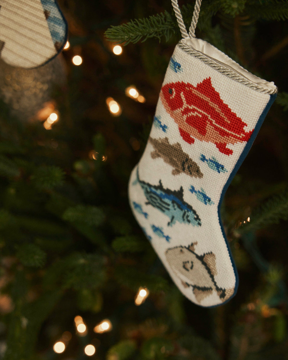 The lifestyle view of the Southern Tide Coastal Catch Needlepoint Stocking by Southern Tide - White