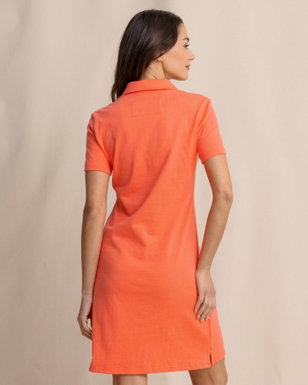 The back view of the Southern Tide Demi Solid Short Sleeve Polo Dress by Southern Tide - Sunset Coral