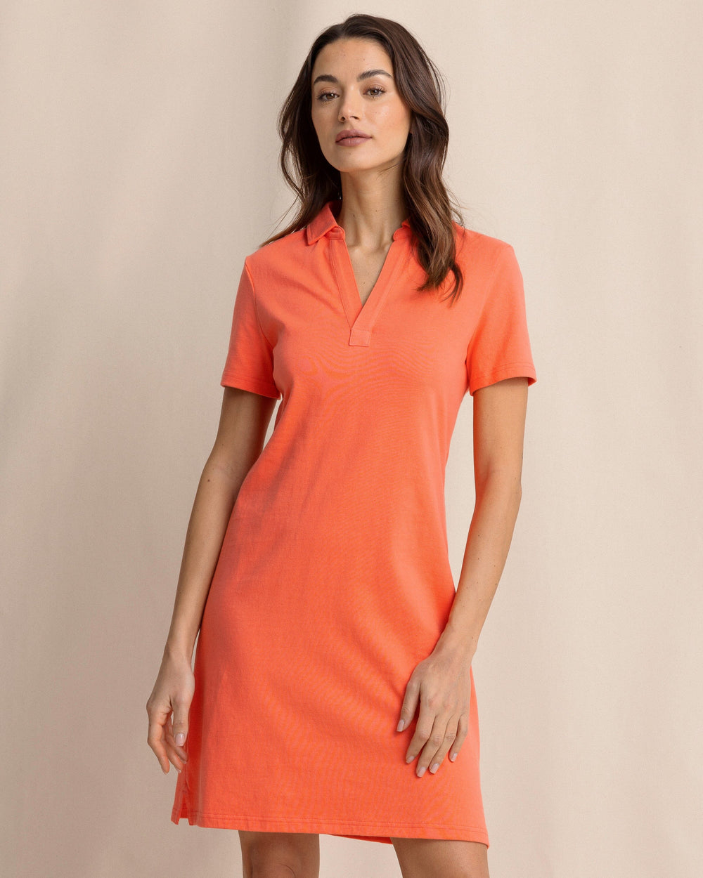 The front view of the Southern Tide Demi Solid Short Sleeve Polo Dress by Southern Tide - Sunset Coral