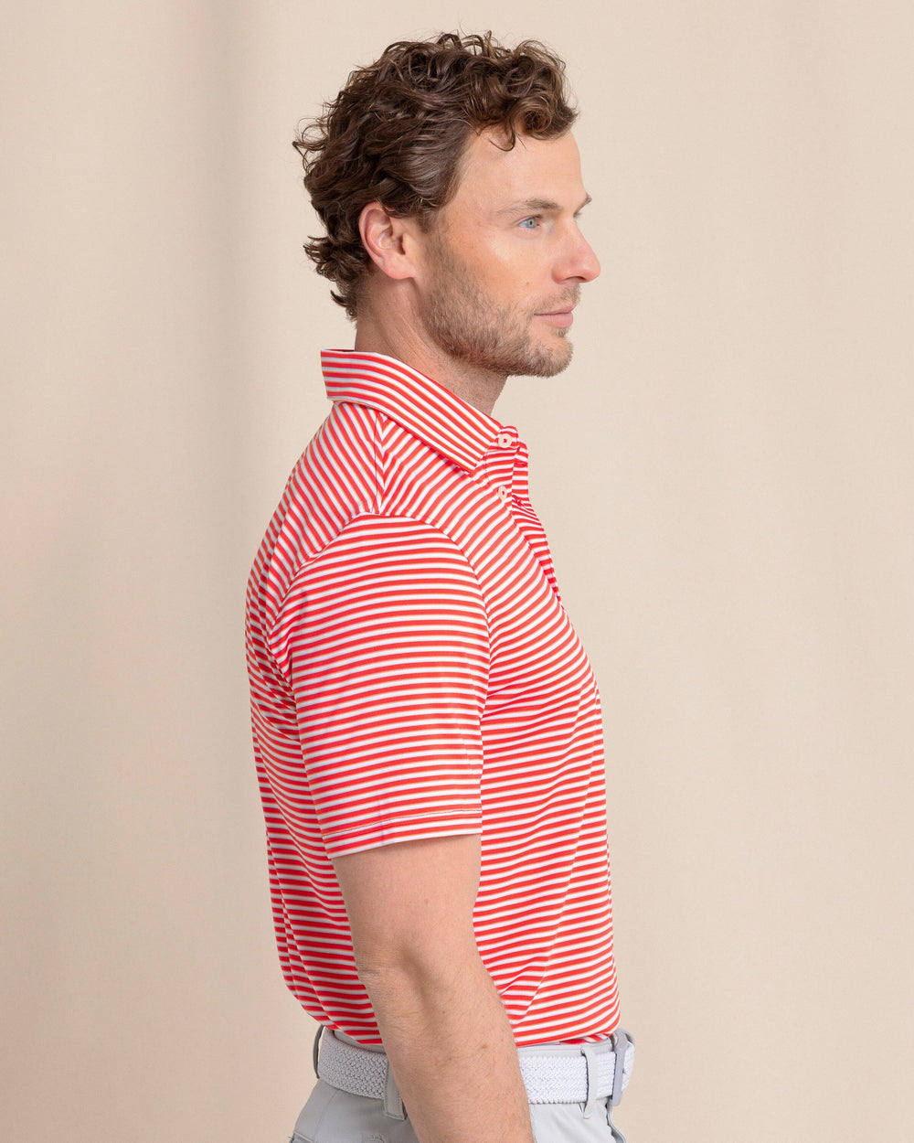 The side view of the Southern Tide Driver Caravel Stripe Polo by Southern Tide - Poppy Red