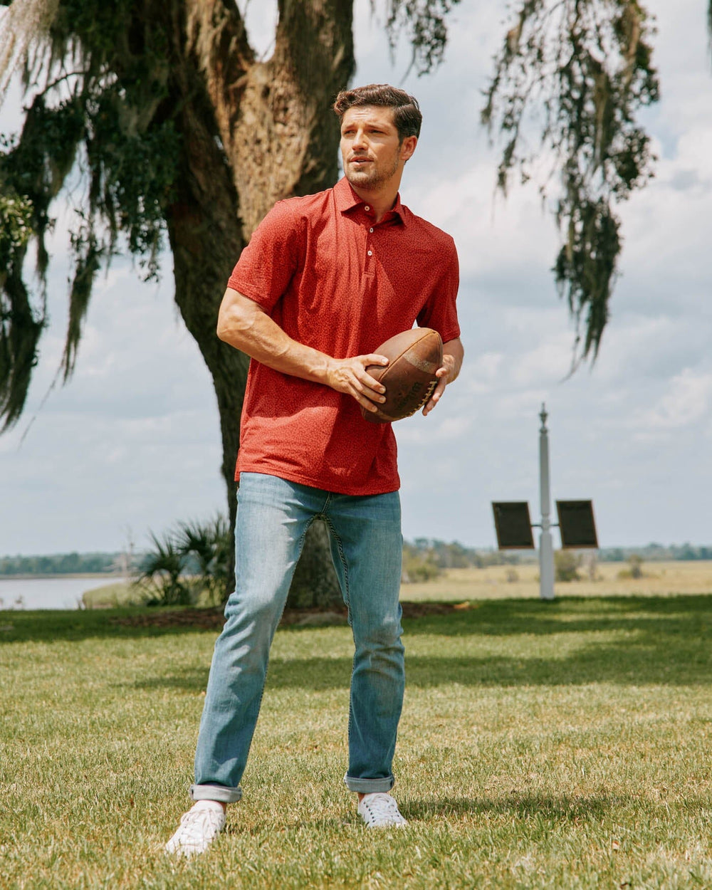 The lifestyle view of the Southern Tide Driver Gameplay Polo by Southern Tide - Chianti