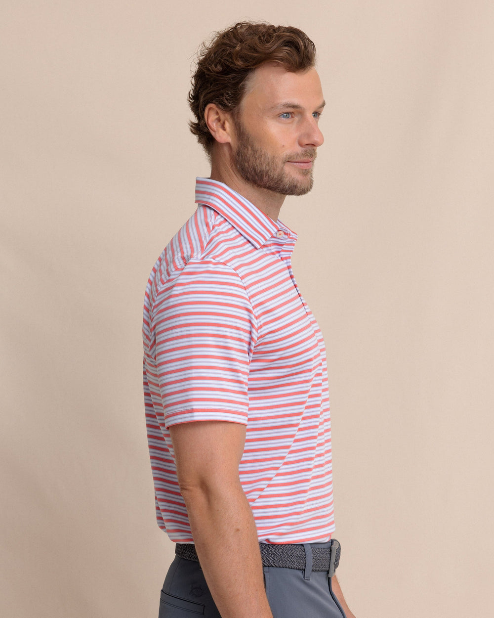 The side view of the Southern Tide Driver Ocean Hill Stripe Polo by Southern Tide - Sunkist Coral