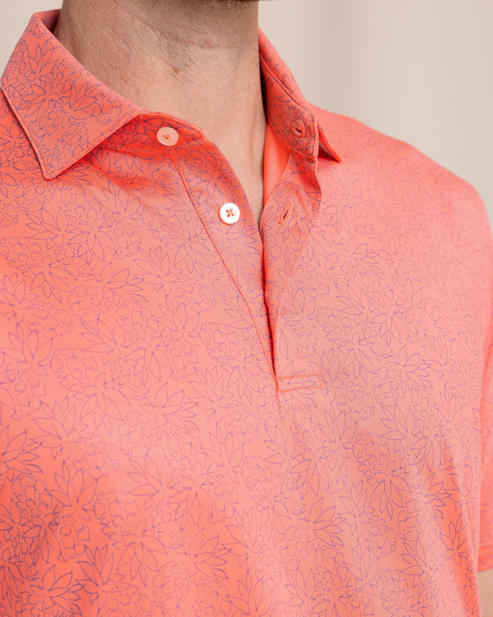 The front detail view of the Southern Tide Driver Pineapple Paradise Printed Polo by Southern Tide - Sunset Coral