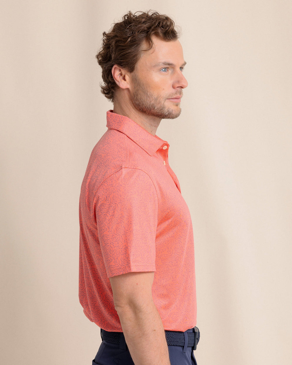 The side view of the Southern Tide Driver Pineapple Paradise Printed Polo by Southern Tide - Sunset Coral